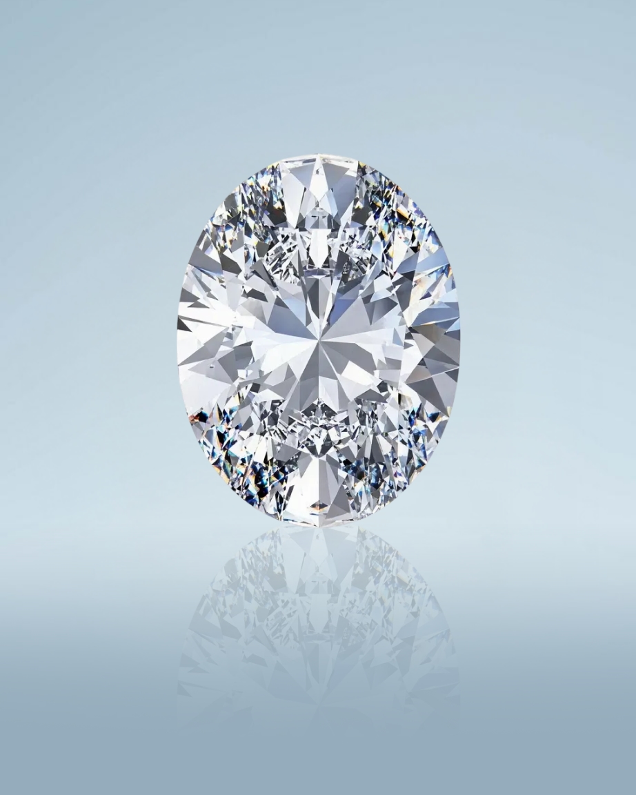 Kay oval-cut diamond showcased in a close-up gemstone portrait, highlighting elongated brilliance, exceptional sparkle, and precision faceting with a reflective finish against a soft blue background.