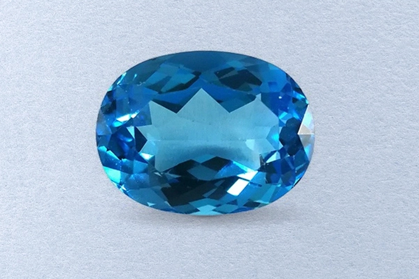 Kay Blue Topaz – Oval-cut blue topaz gemstone showcasing vibrant ocean-blue color and dazzling faceted brilliance.