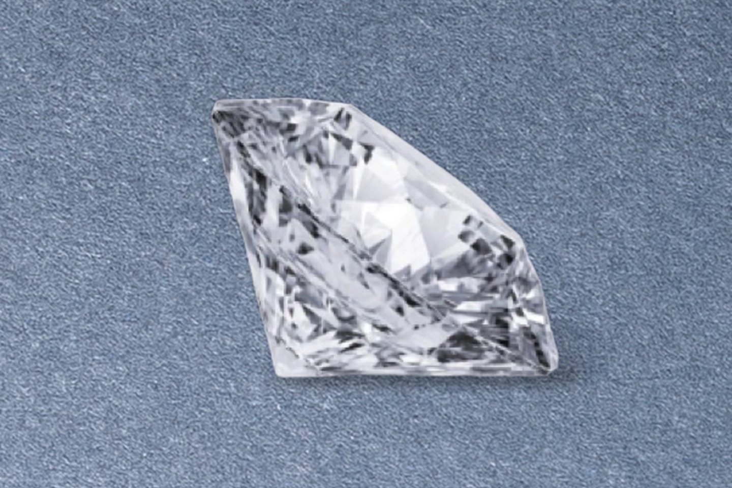 Kay brilliant-cut diamond viewed from the side, showcasing exceptional clarity, precise faceting, and radiant sparkle against a neutral background
