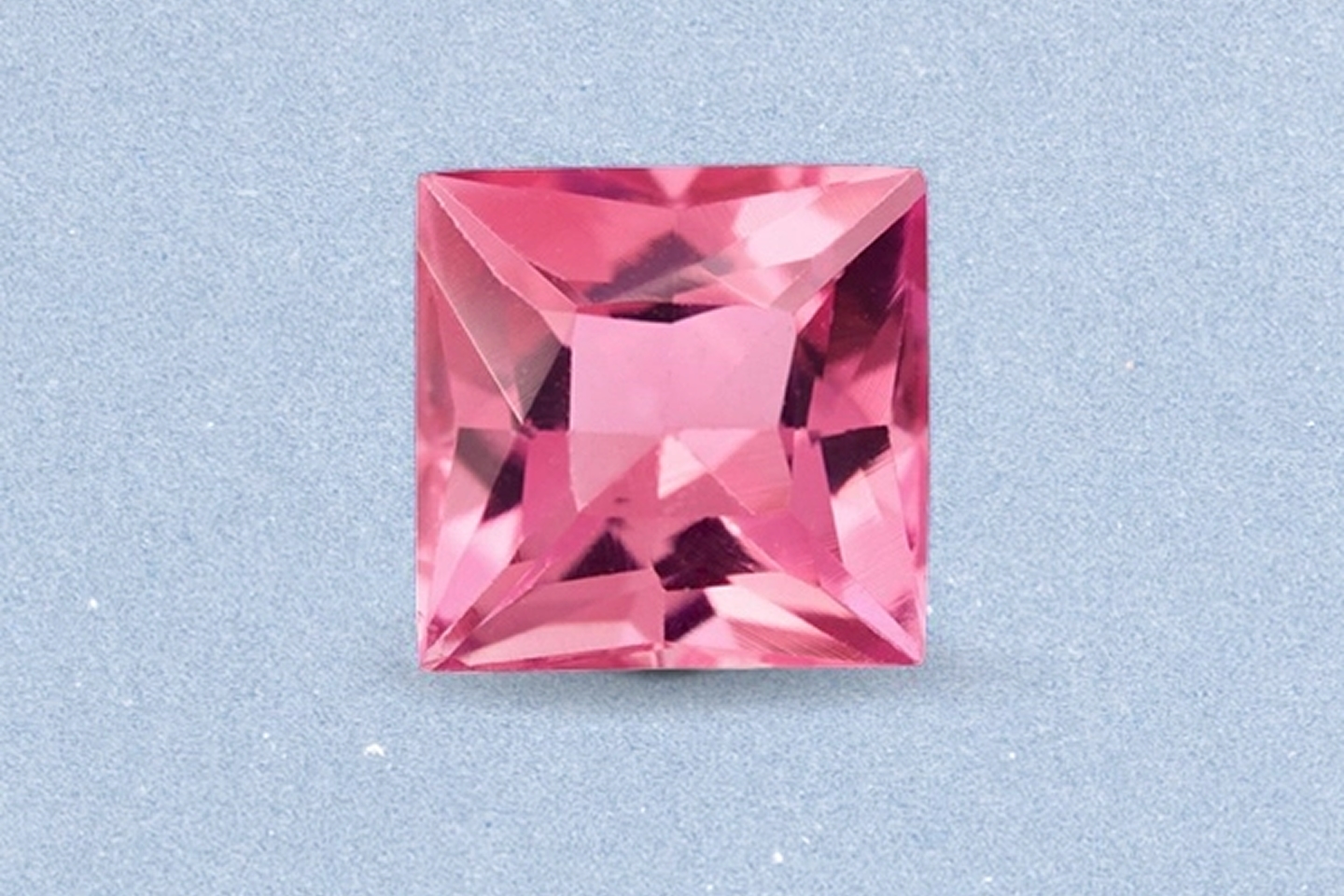 Kay princess-cut pink tourmaline gemstone featuring vibrant rosy pink color, sharp faceting, and brilliant sparkle on a light neutral background