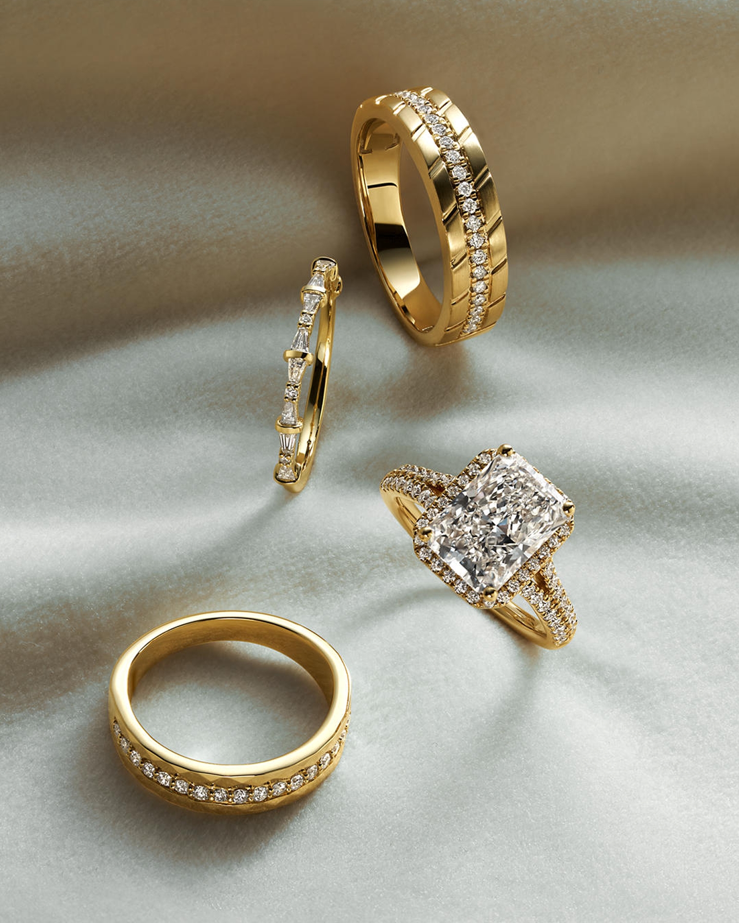 Kay diamond engagement ring collection featuring a radiant-cut diamond halo engagement ring, diamond wedding bands and a yellow gold diamond band, displayed on a satin-inspired background showcasing bridal jewelry craftsmanship and brilliance.