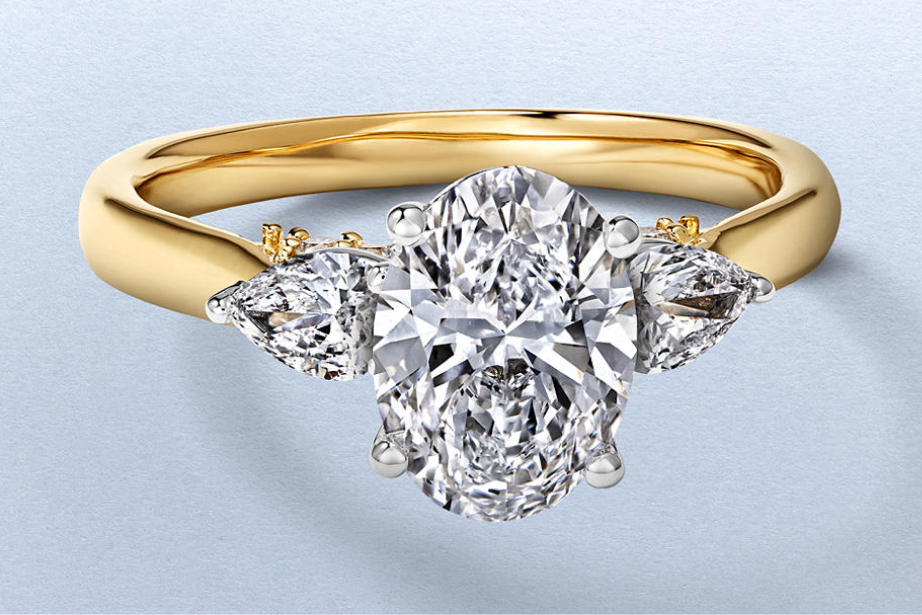 Kay oval-cut diamond engagement ring featuring a brilliant center diamond and pear-shaped side stones in a classic yellow gold three-stone setting.