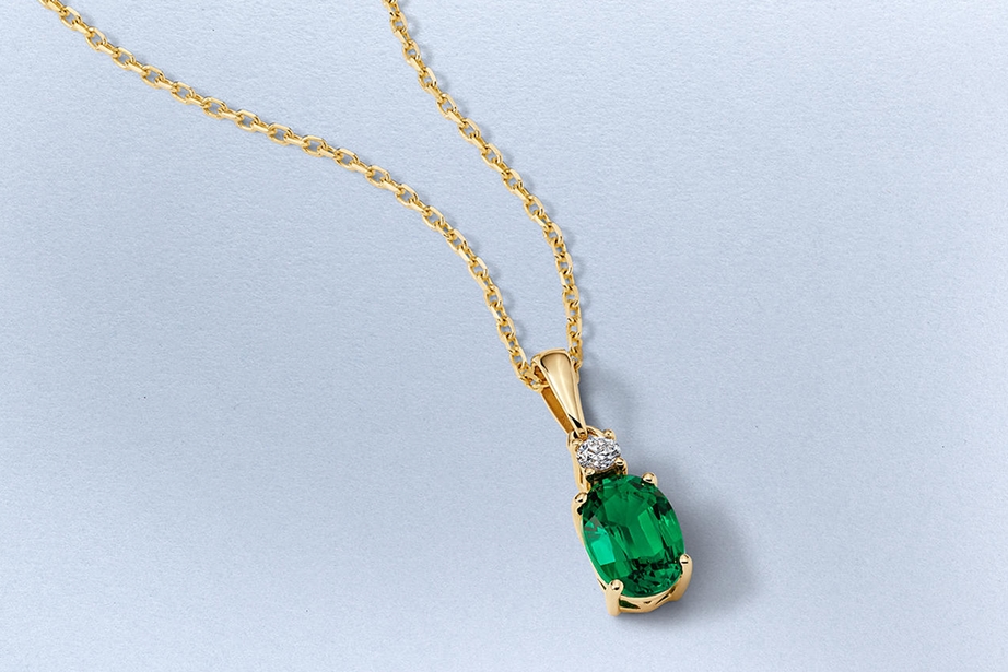 Kay emerald-cut green gemstone pendant necklace featuring a vibrant solitaire gemstone accented by a round diamond in a classic yellow gold setting.
