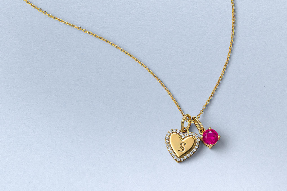 Kay gold vermeil heart initial necklace featuring a diamond-accented heart charm and vibrant pink gemstone pendant
