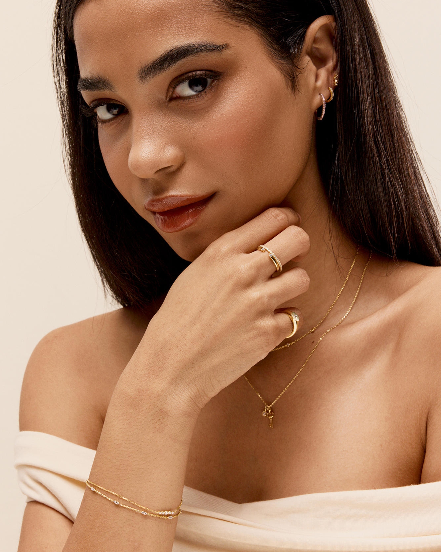 Kay yellow vermeil jewelry collection featuring diamond-accented hoop earrings, layered pendant necklaces, stackable rings, and a delicate diamond station bracelet styled for everyday elegance