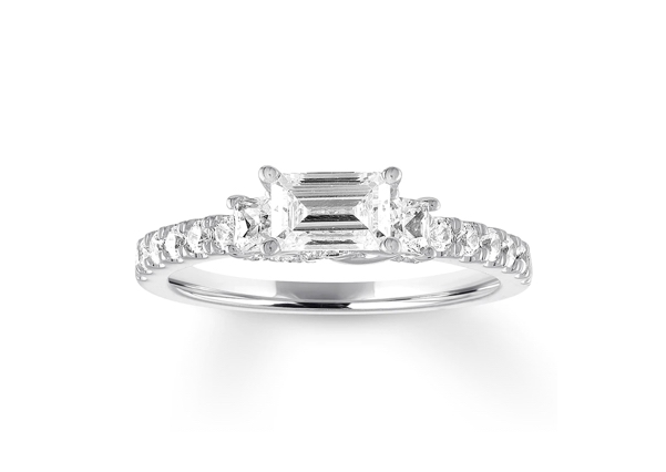 An emerald-cut diamond in a three stone solitaire setting