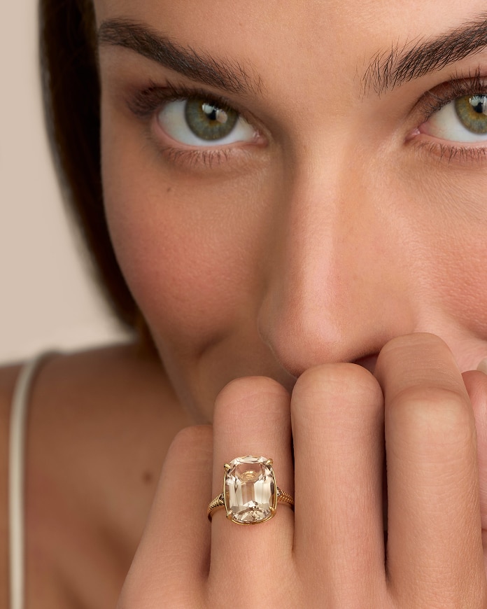 Close up of woman resting chin on hand wearing champagne quartz Le Vian Antique Cushion ring