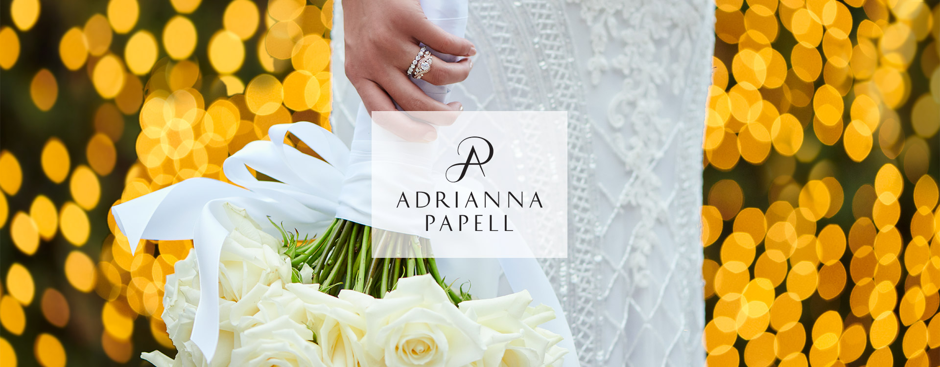 Bride holding flower bouquet and wearing her Adrianna Papell engagement ring. Shop engagement rings from the Adrianna Papell collection.