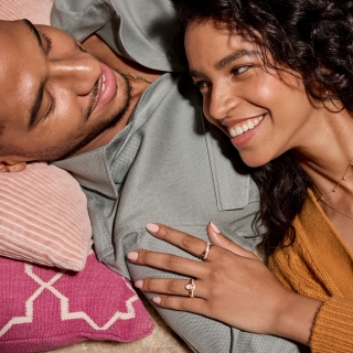 Woman wearing jewelry and laying on man's chest