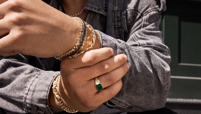 Man wearing multiple bracelets and a gold ring