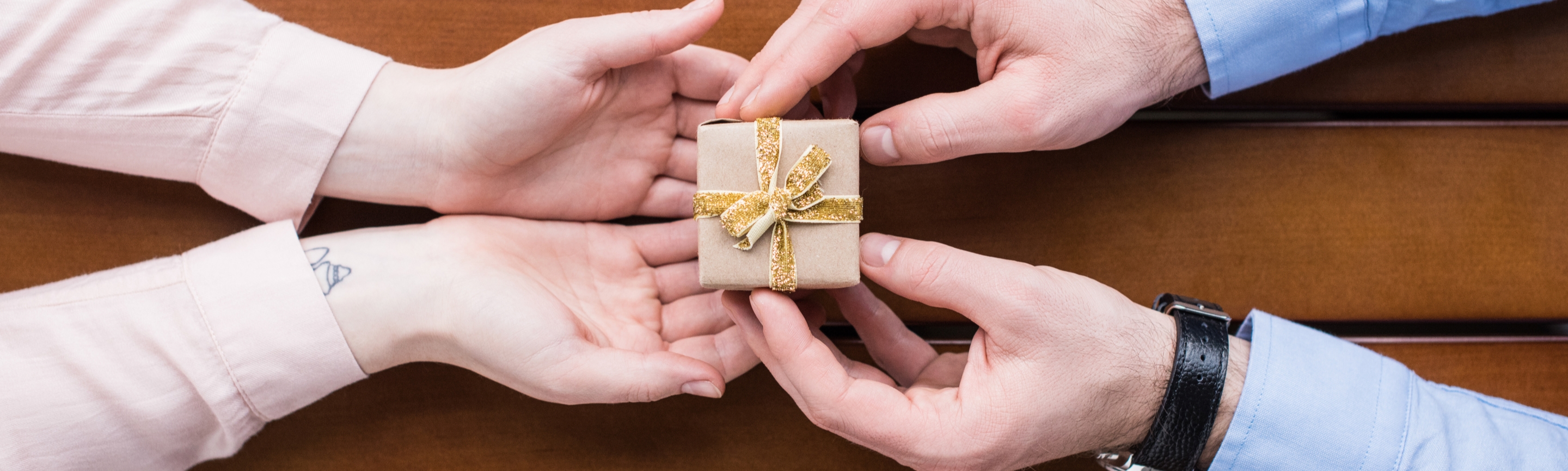 A man handing over a gift box with a bow to someone special