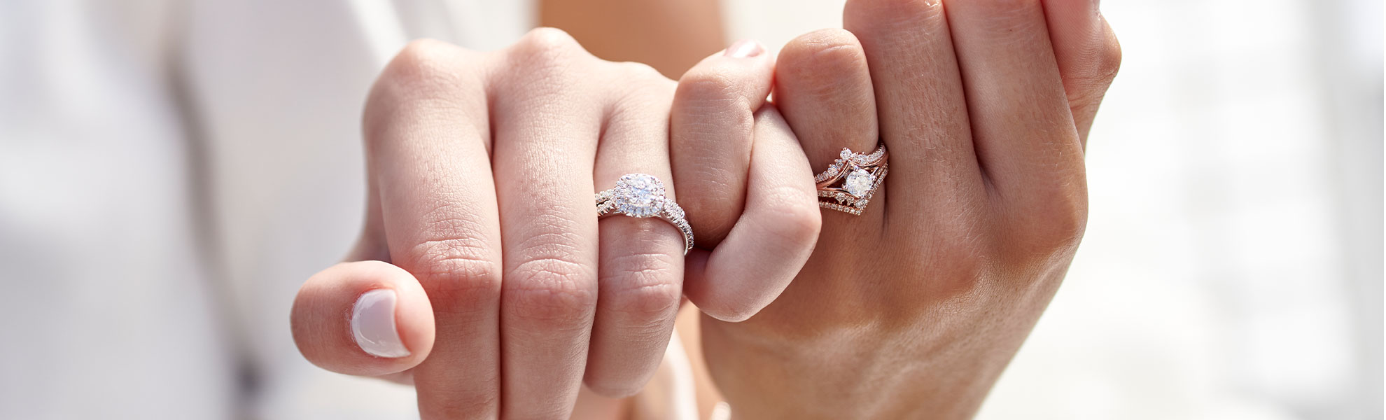 Women locking fingers showing off anniversary bands from KAY