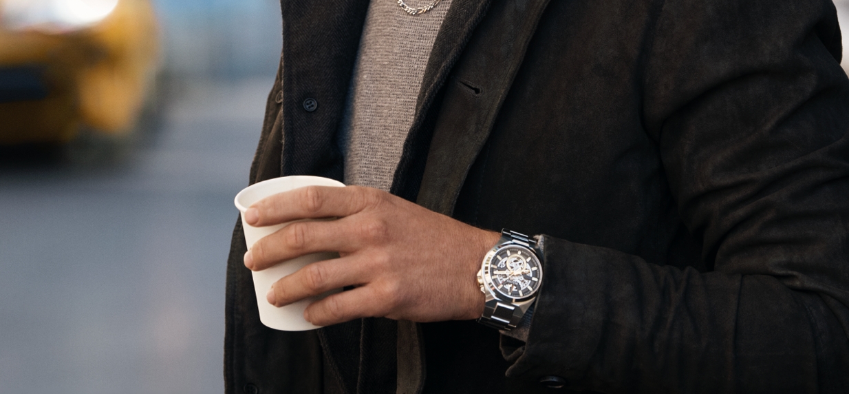 Image of man wearing classic watch holding a coffee cup