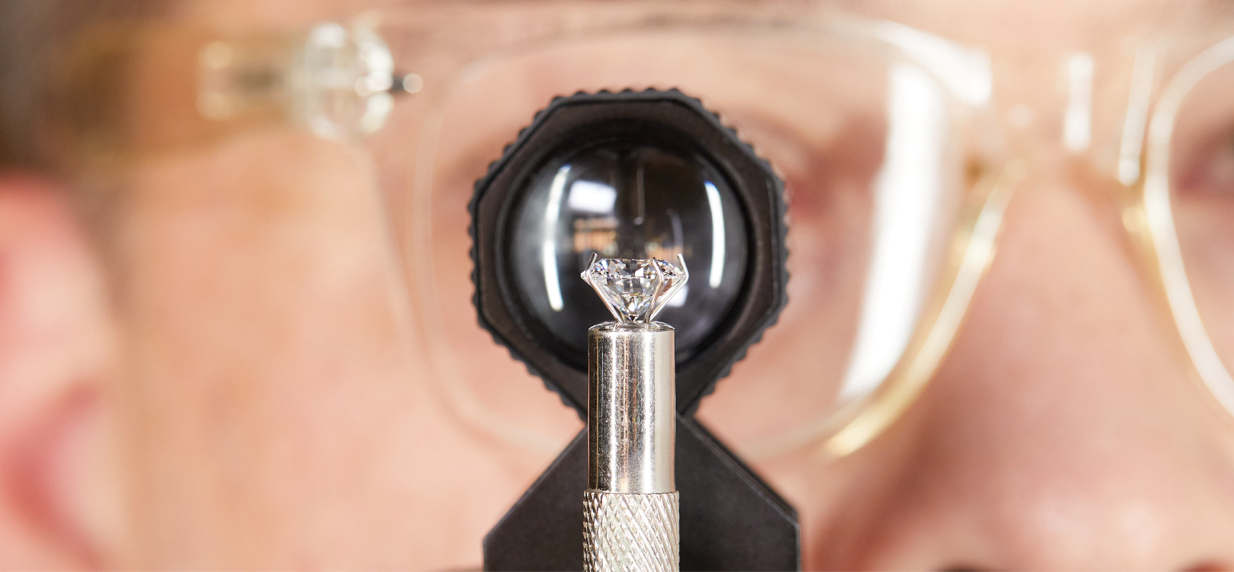 Image of person wearing glasses inspecting a diamond