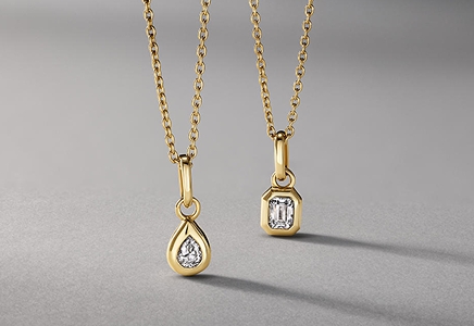 Two gold plated necklaces with a tear drop pendant and an emerald-shaped pendant from KAY.