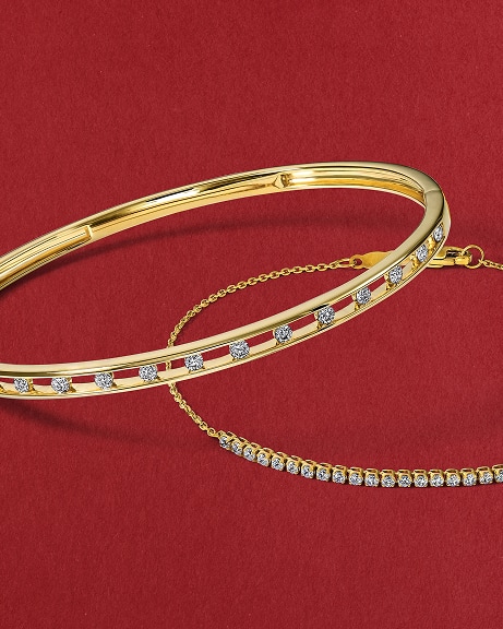 Two gold, diamond bracelets stacked on top of each other, from KAY.