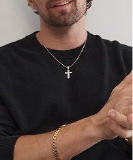 A man wearing a gold chain with a gold cross, and a gold chain bracelet from KAY.