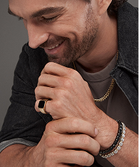 A man wearing a black diamond ring, with a stainless steel and diamond tennis bracelet from KAY.