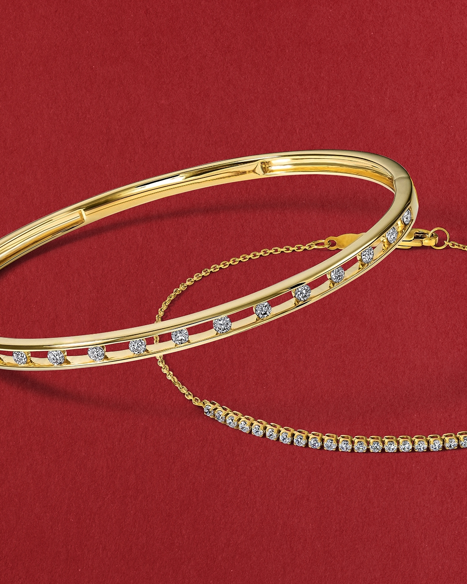Two gold, diamond bracelets stacked on top of each other, from KAY.