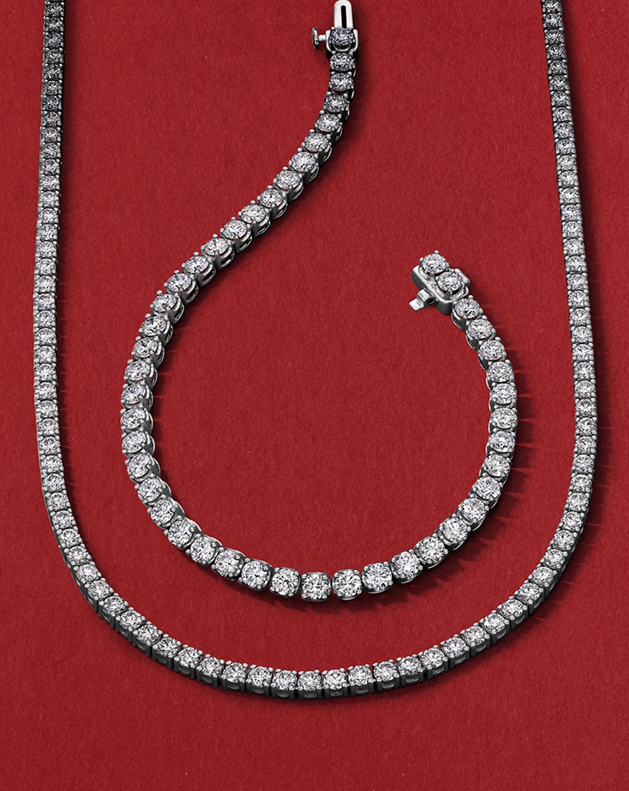 A diamond tennis necklace wrapped around a diamond tennis bracelets, from KAY.