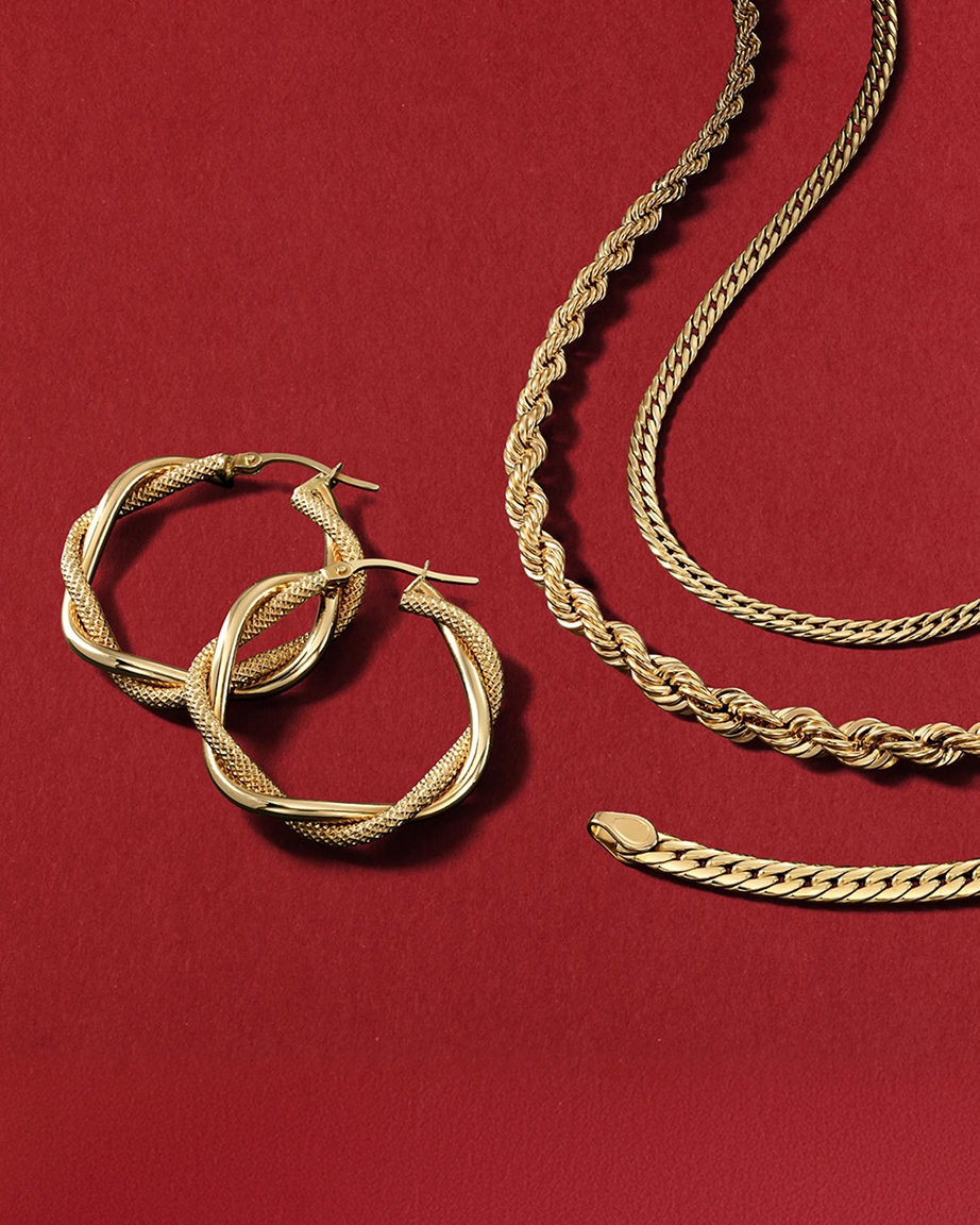 A set of gold hoops next to three different gold chain types, from KAY.