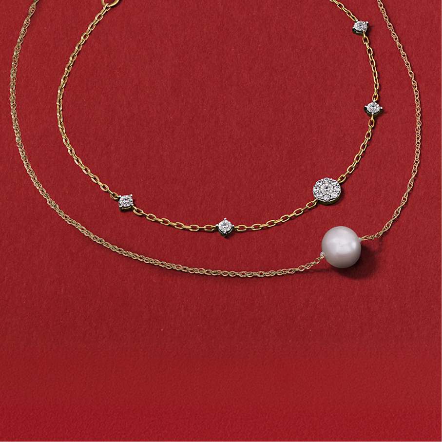 Two gold chains, one with a large pearl, and the other with five diamonds in between links, from KAY.