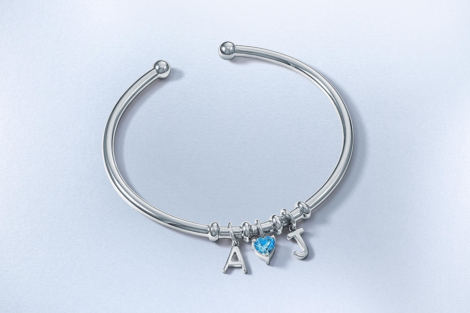 A personalized, silver bangle with initial charms and a birthstone by KAY.