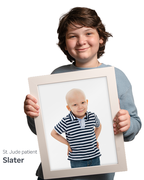A young boy hold a framed photo of St. Jude patient, Slater.