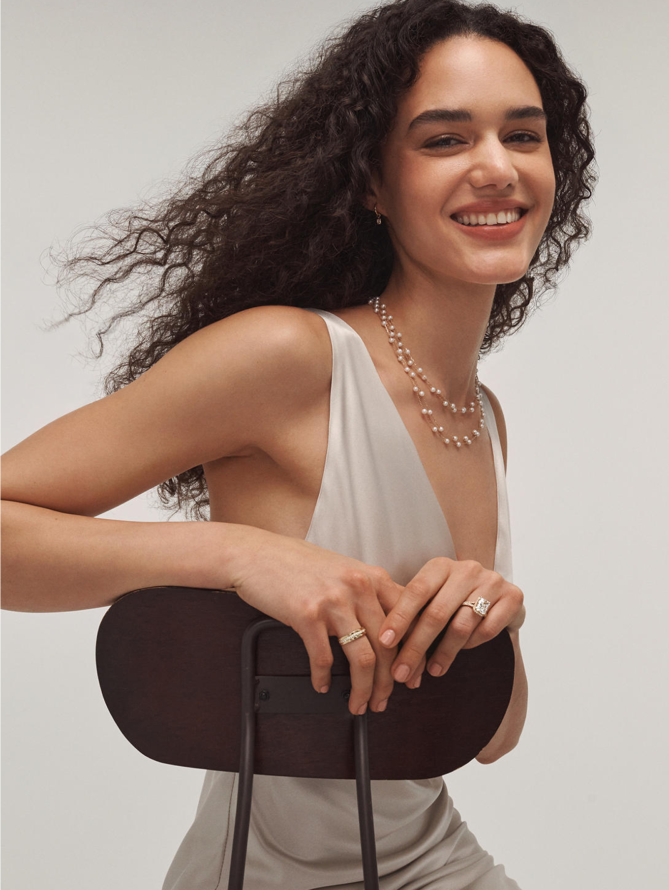 A woman wearing multipl pearl necklaces from KAY.