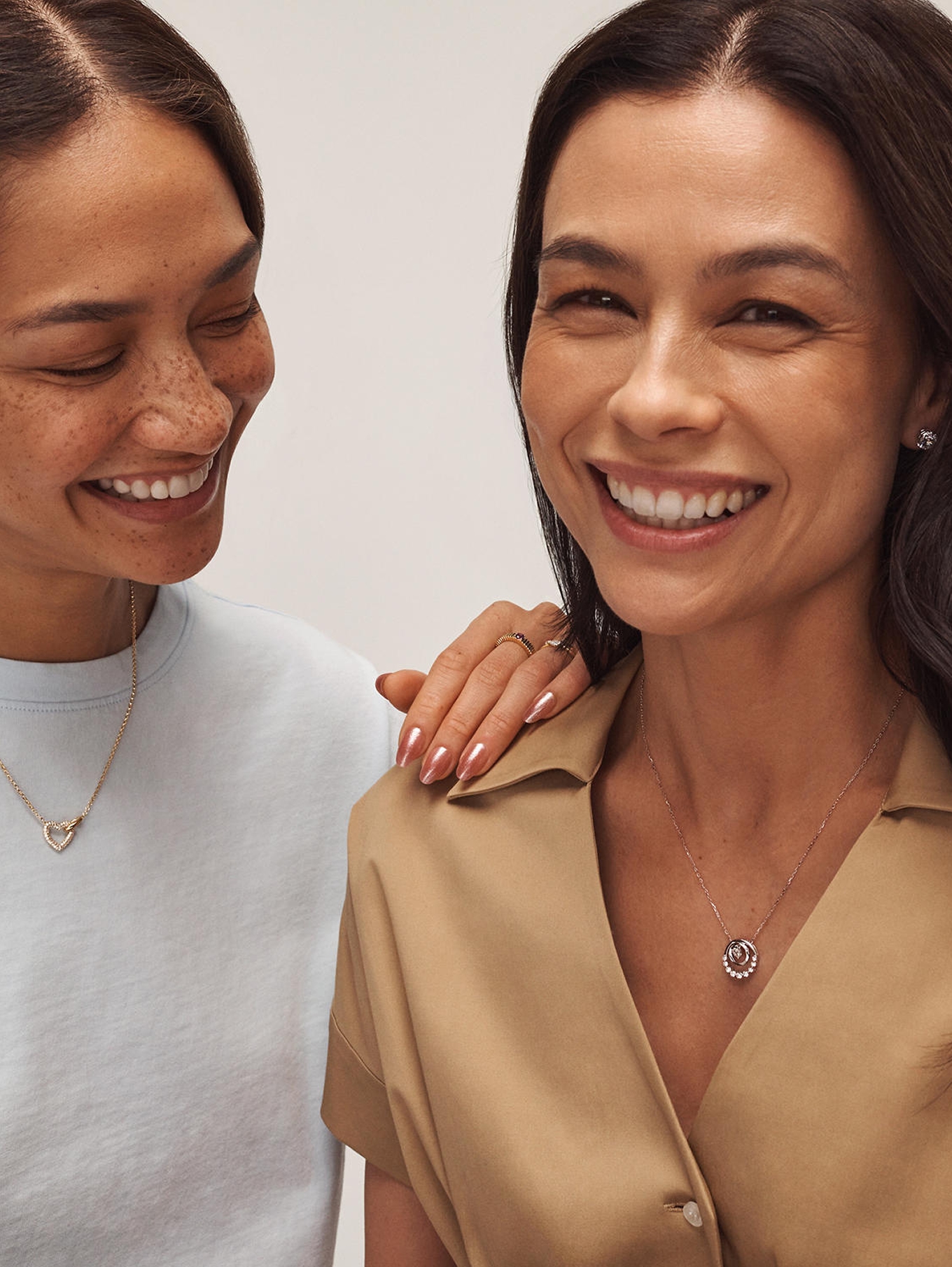 Two woman wearing personalized necklaces from KAY.