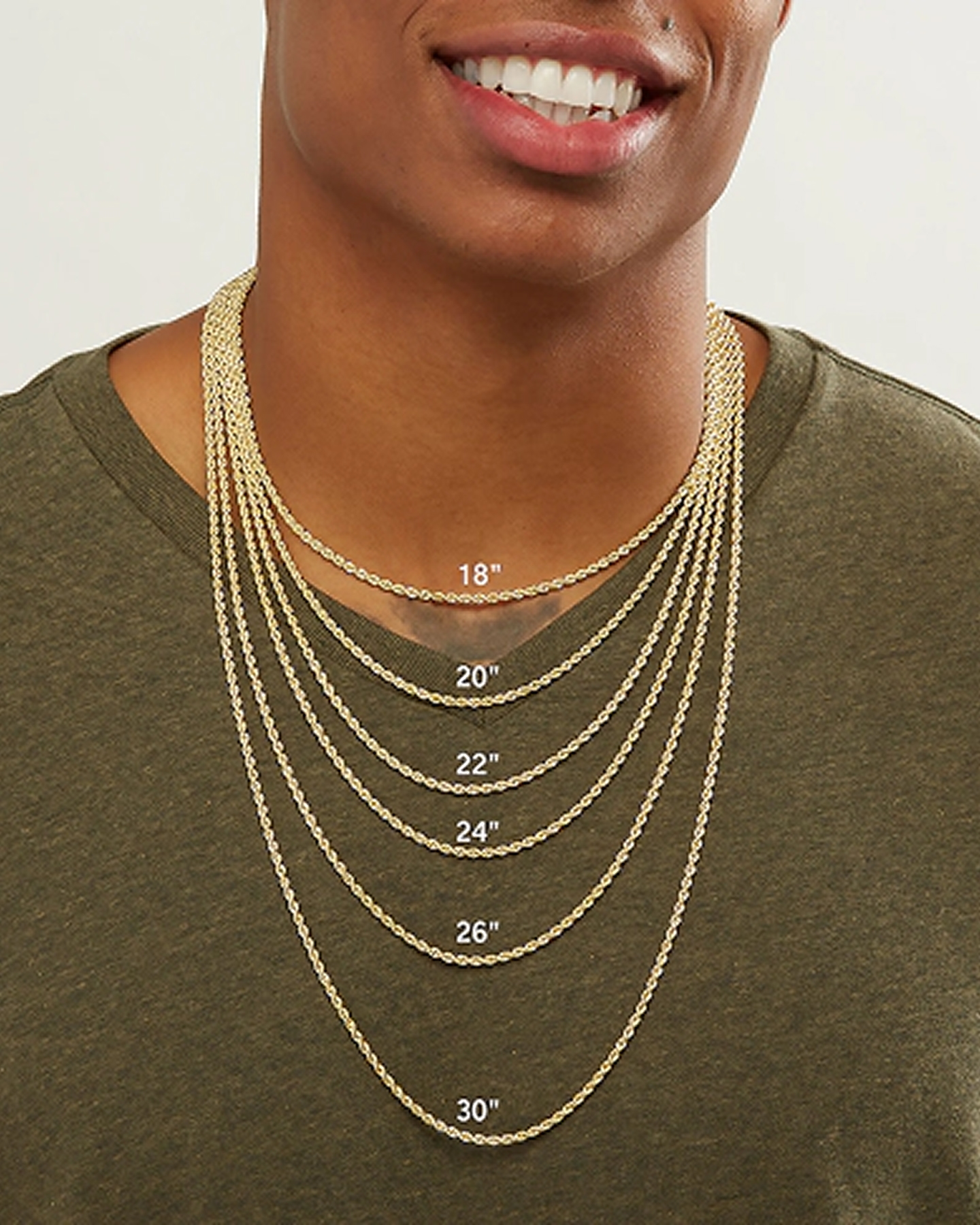 A man wearing multiple gold chains, showing differing lengths.