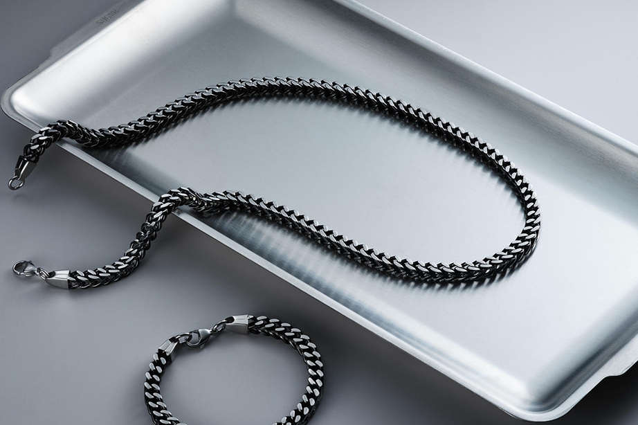 A stainless steel figaro chain and matching bracelet.