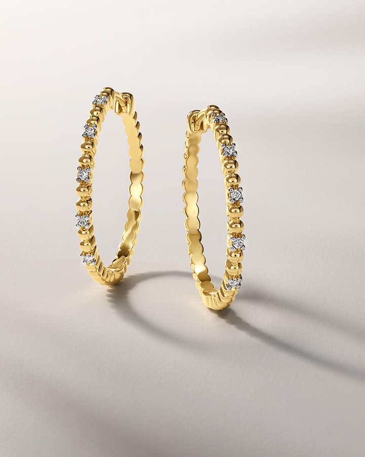 A pair of gold, diamond earrings from KAY.