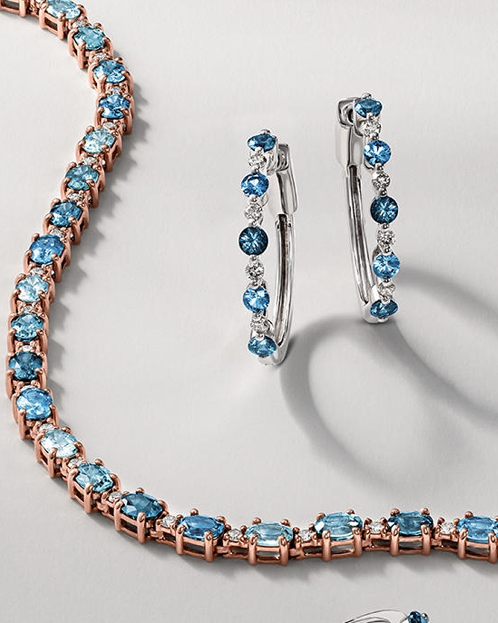 A sapphire and gold tennis bracelet with a matching pair of saphire earrings by KAY.
