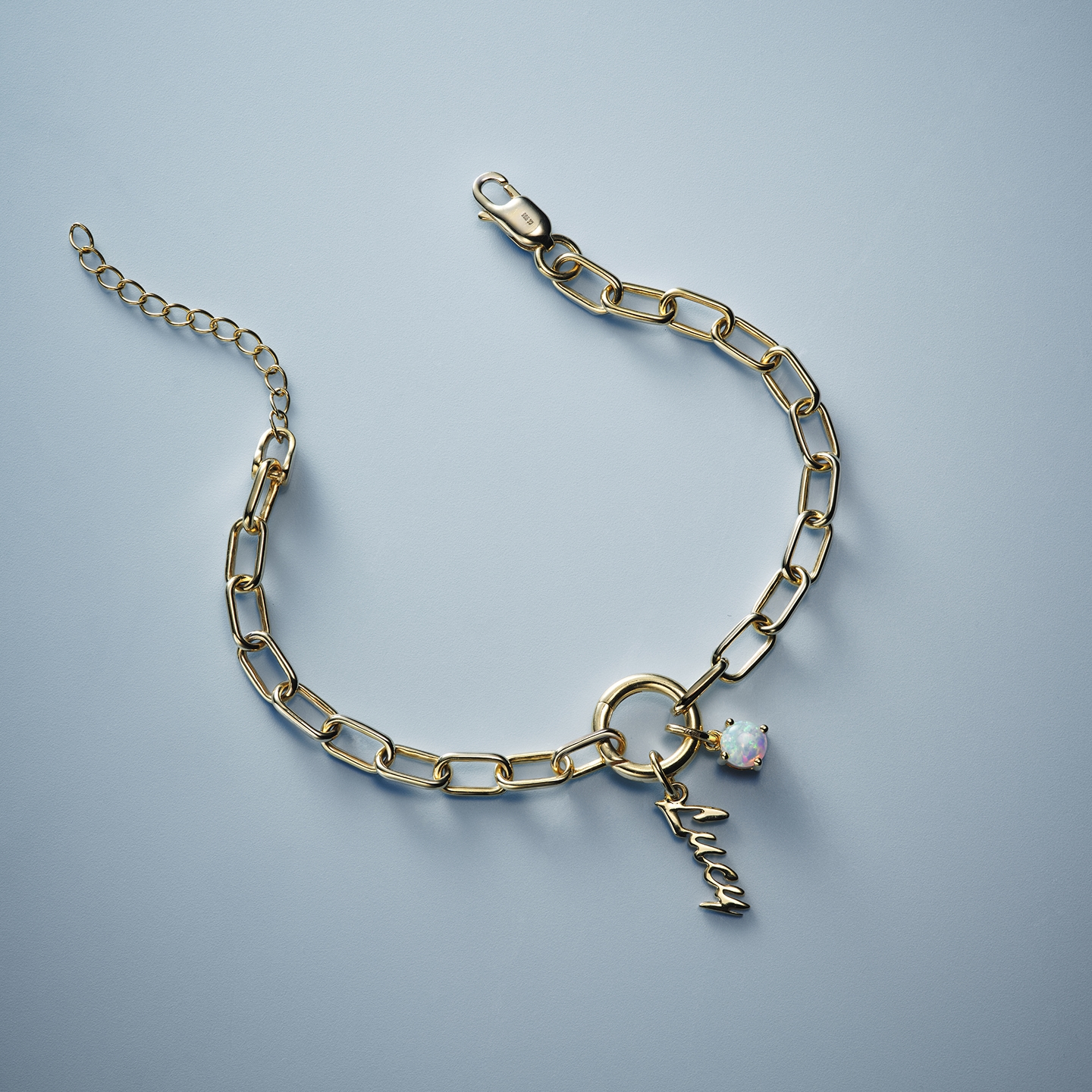 A gold, chain link necklace with a personalized name pendant and birthstone from KAY.