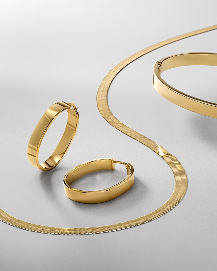 A pair of gold earrings, with a matching herringbone necklace and a bangle from KAY.