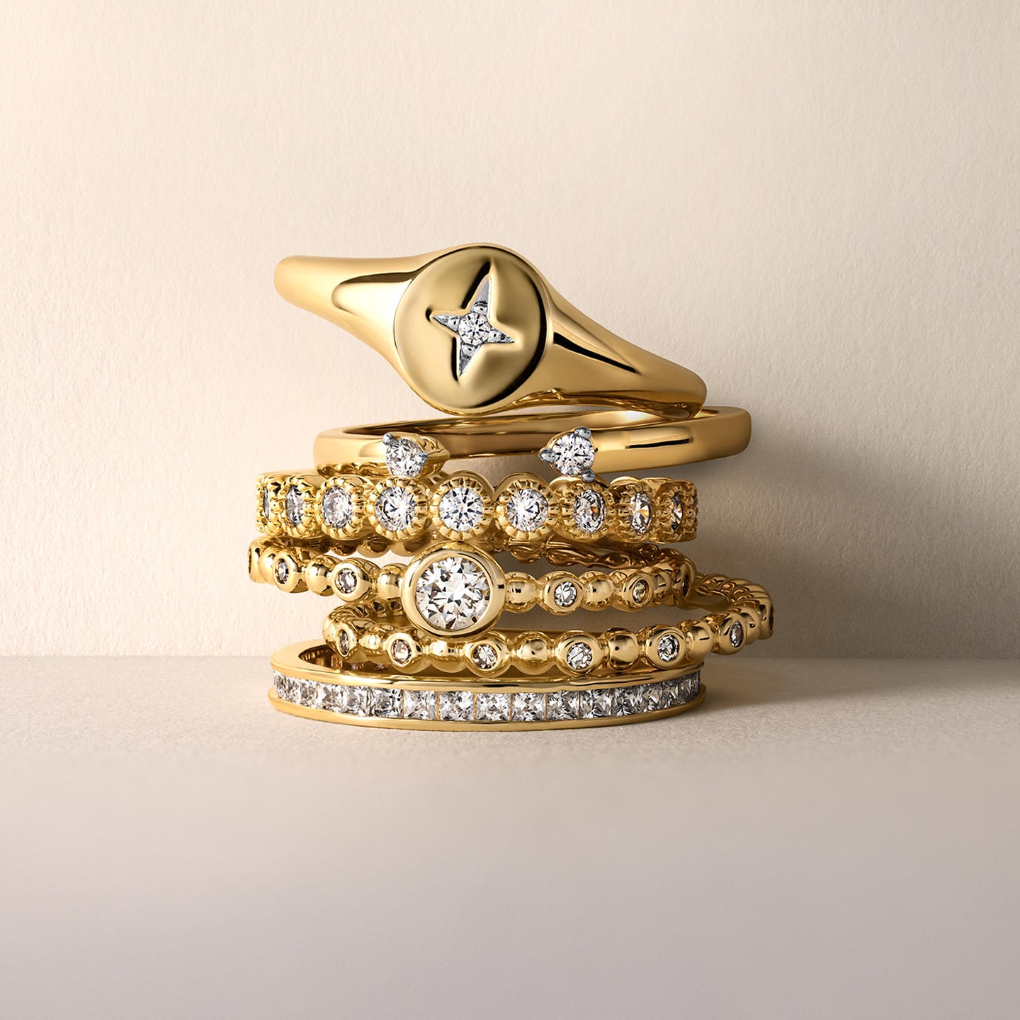 A stack of gold, diamond inlaid rings from KAY.