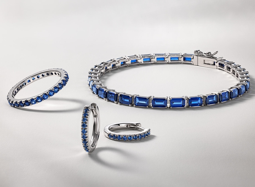 A matching set of sapphire inlaid earrings, a ring, and a bangle from KAY.