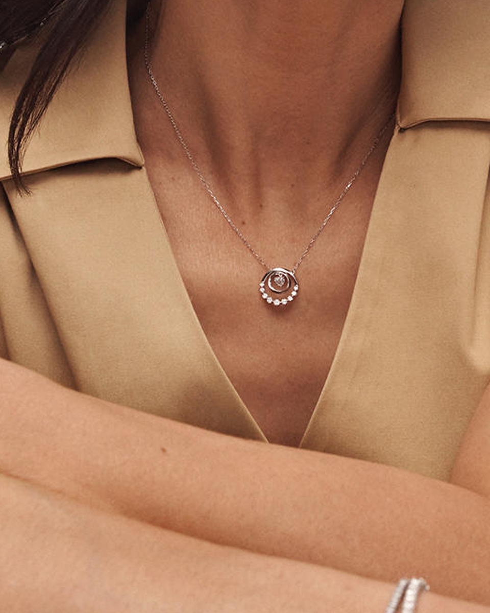 A model wearing a white gold, diamond pendant necklace from KAY.