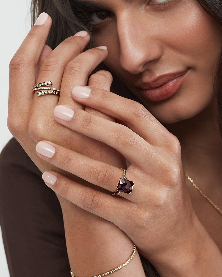 A model showcasing a diamond ring and a garnet gemstone ring by Le Vian from KAY.
