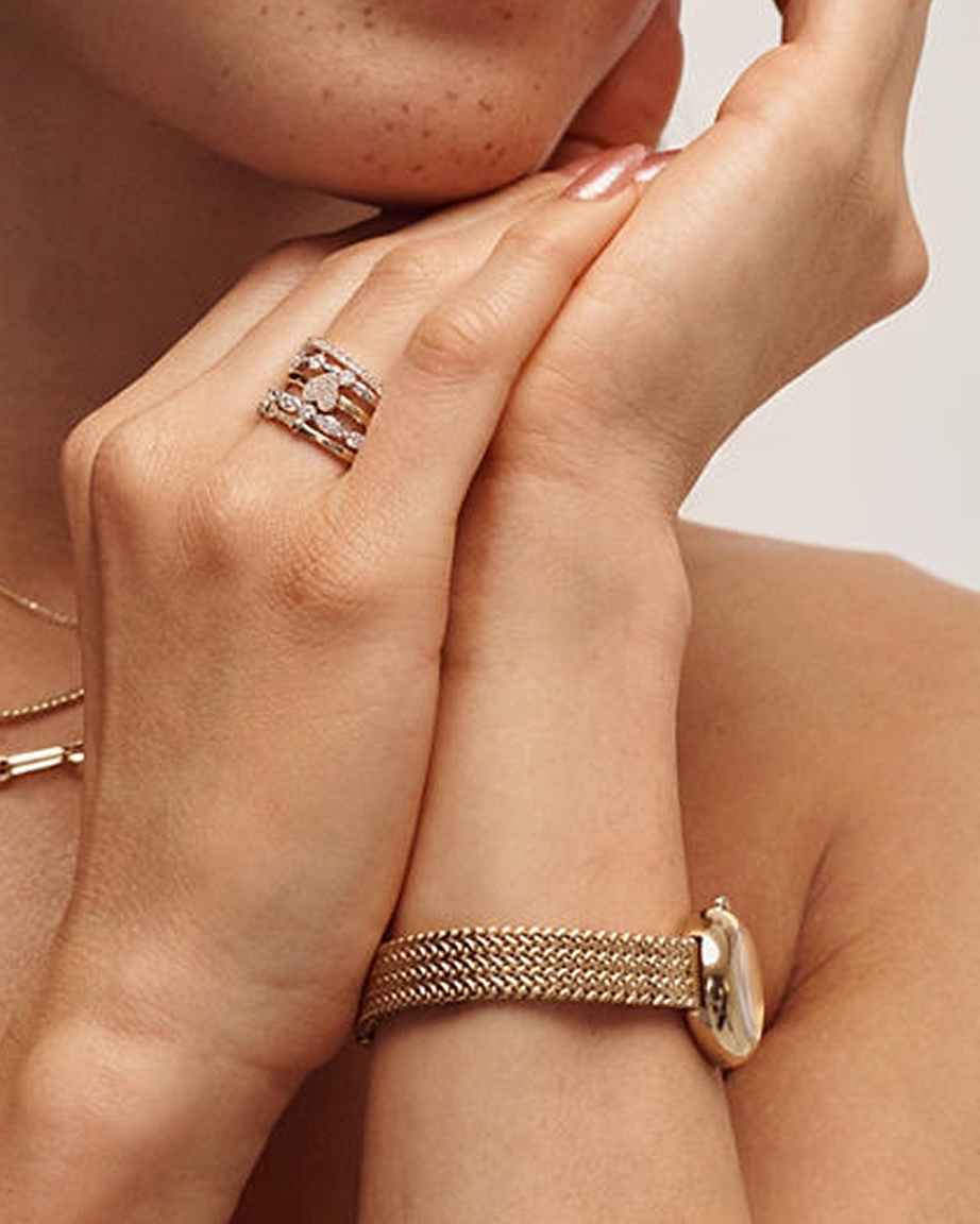 A woman wearing multiple, stackable diamond rings from KAY.