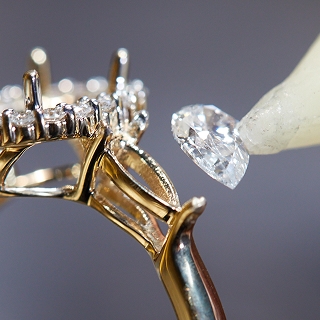 Image of diamond being placed in ring setting