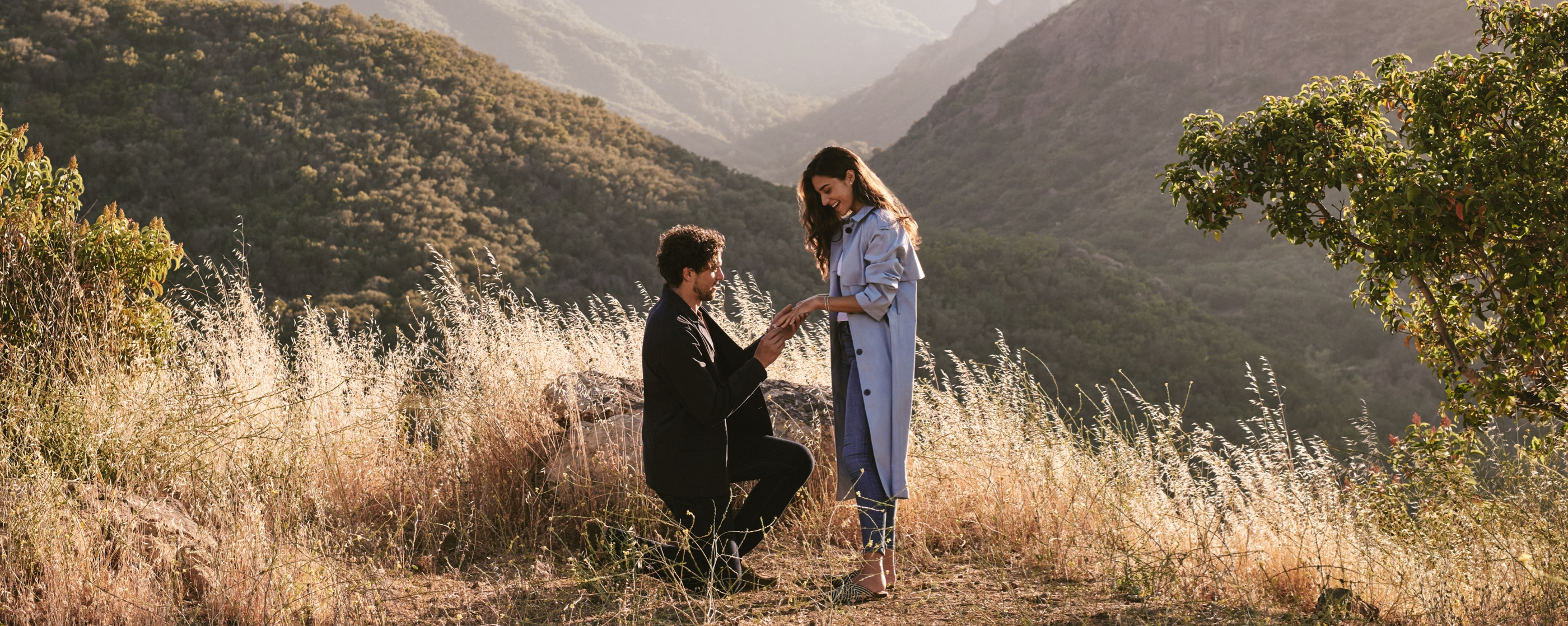 Man proposing to a woman on a mountainside