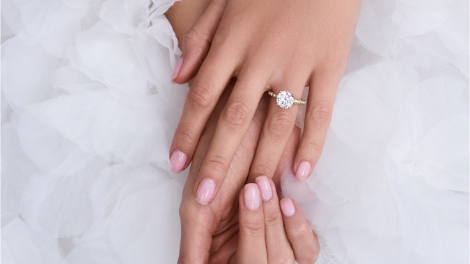 Woman's hands sporting a Lab-created diamond engagement ring 