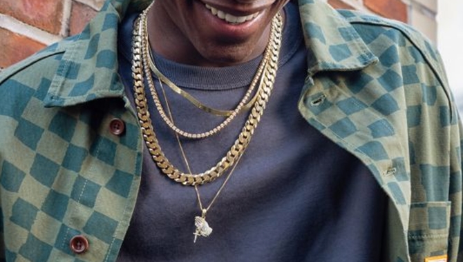 Man wearing layered gold necklaces and chains