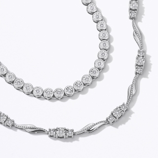 A pair of diamond and silver necklaces.
