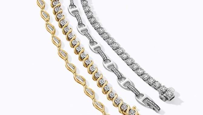 An assortment of four differing gold and silver diamond bracelets.