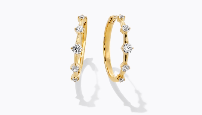 A pair of gold earrings inlaid with diamonds.