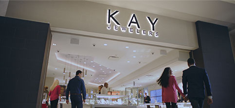 couple walking in to a Kay Jewelers store