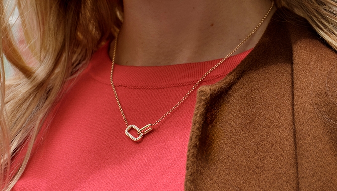 A model showcasing a gold necklaces from STUDIO BY KAY.